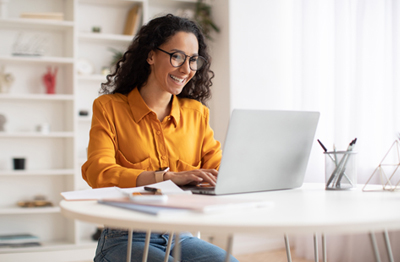 A woman in a yellow blouse managing her Selective Insurance policy online.
